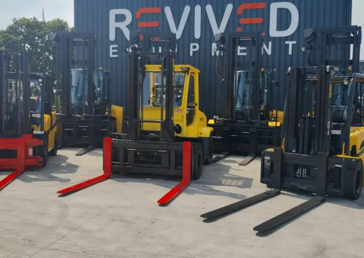 used forklift trucks in front of revived equipment signage